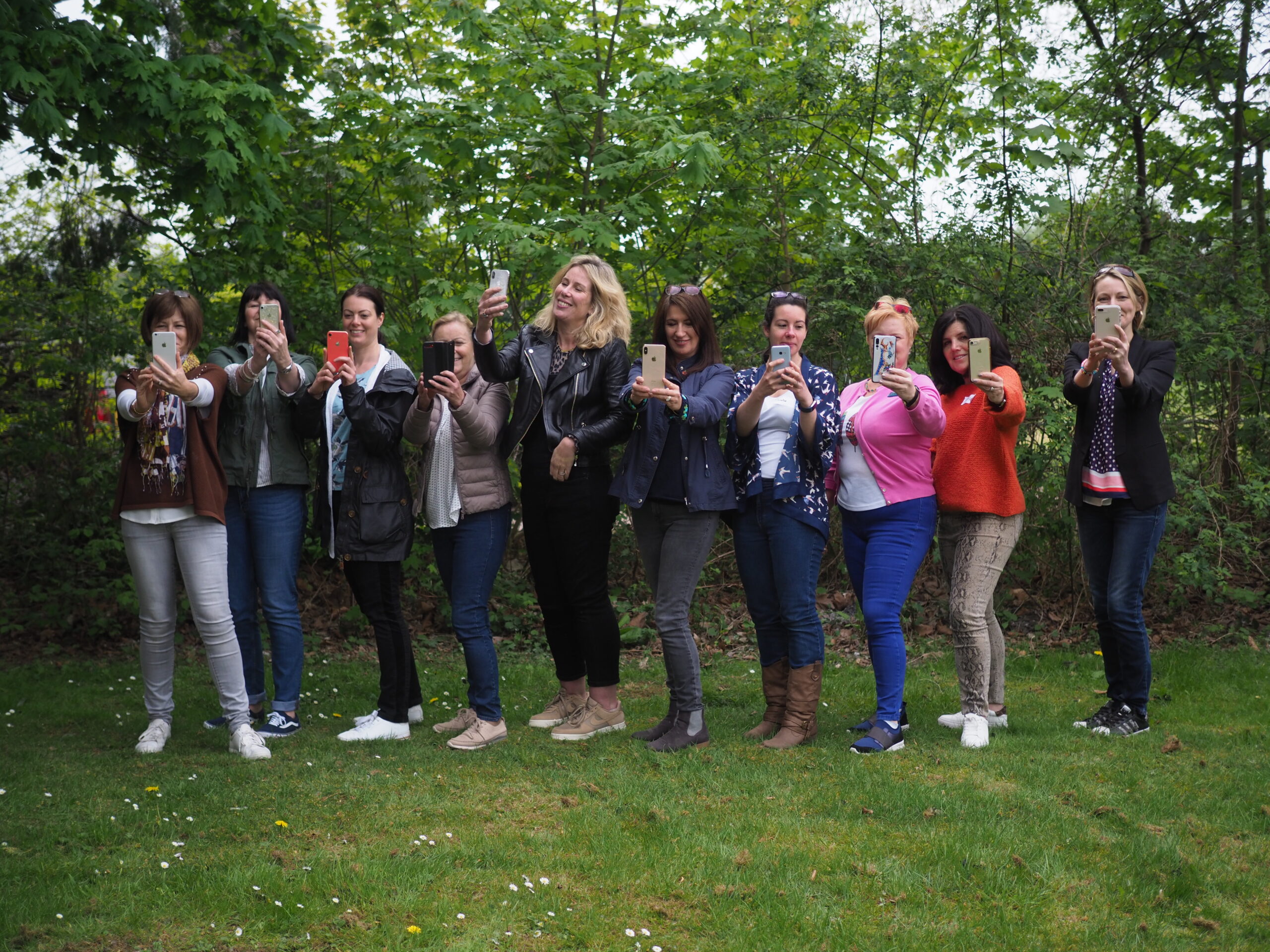 Group of women confidently taking selfies with their phones