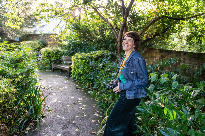 Kerry with her camera on pathway, smiling at the camera